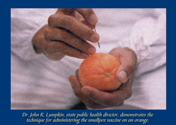 Health care workers practice administering the smallpox vaccine using an orange.